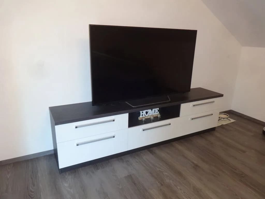 TV-komoda s temno ploščo in belimi predali