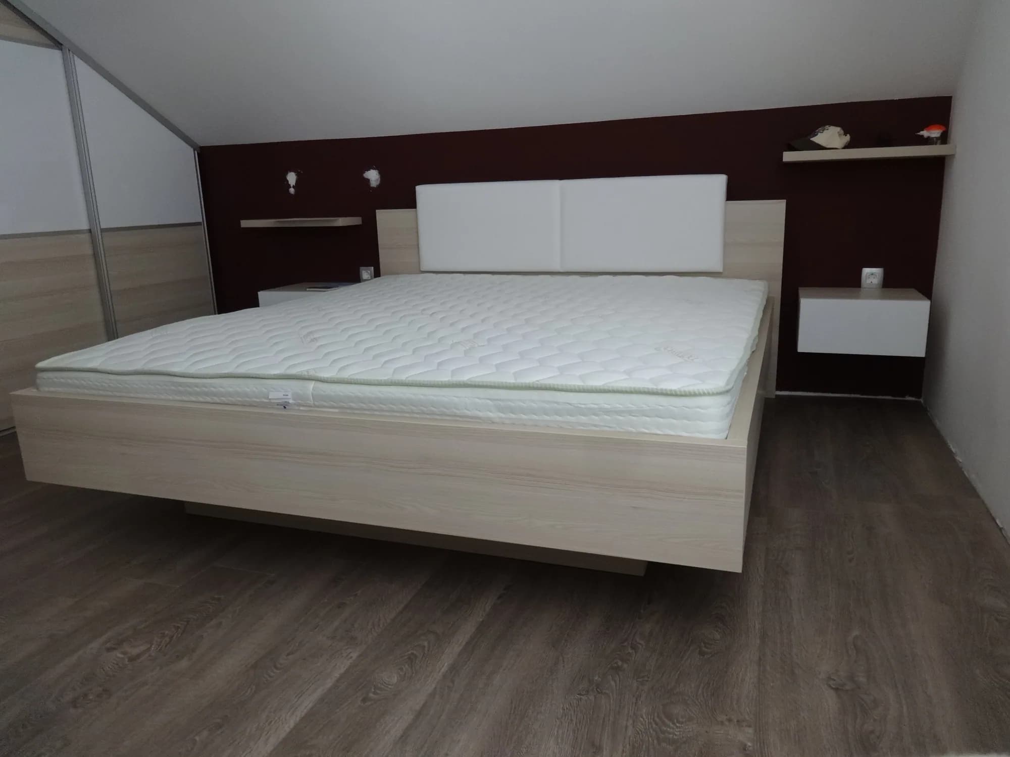 Lebdeča zakonska postelja z oblazinjenim vzglavjem in nočnimi omaricami