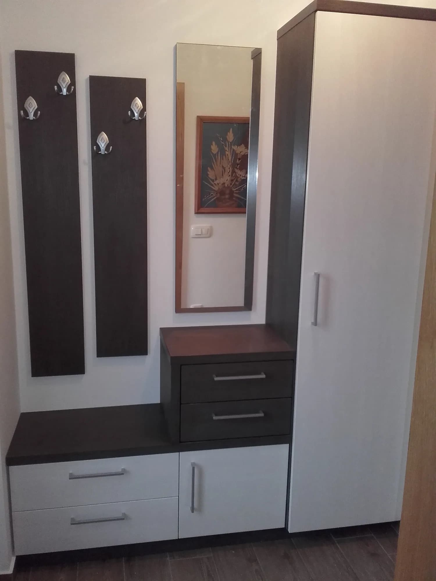 Predsoba s stenskimi paneli, obešalniki in klopjo s predali v temnem lesu